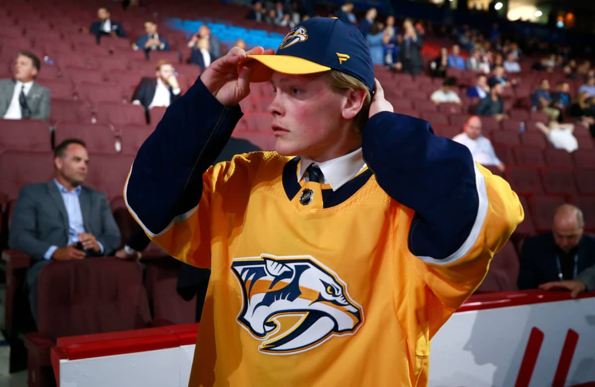 Juuso Pärssinen painaa Nashville Predatorsin lippiksen päähän NHL:n varaustilaisuudessa 2019.