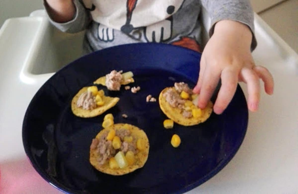 Lapsi syö tacoja lautaselta