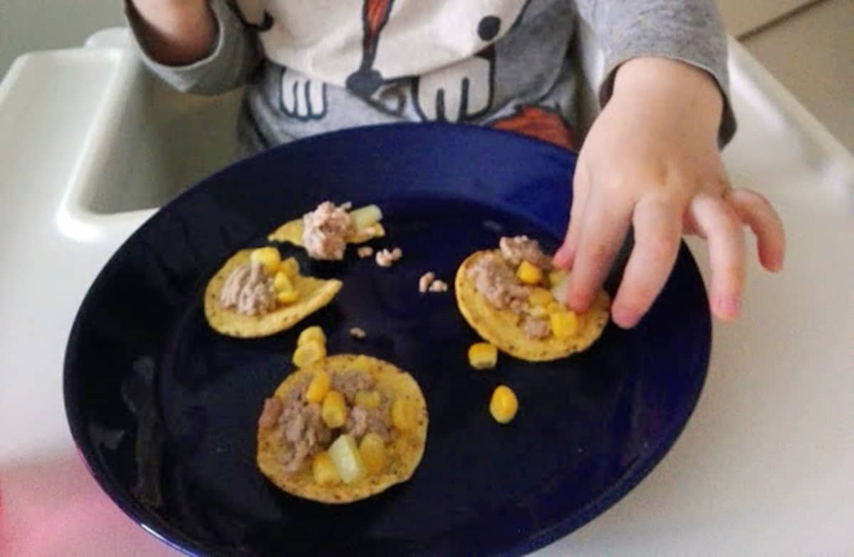Lapsi syö tacoja lautaselta