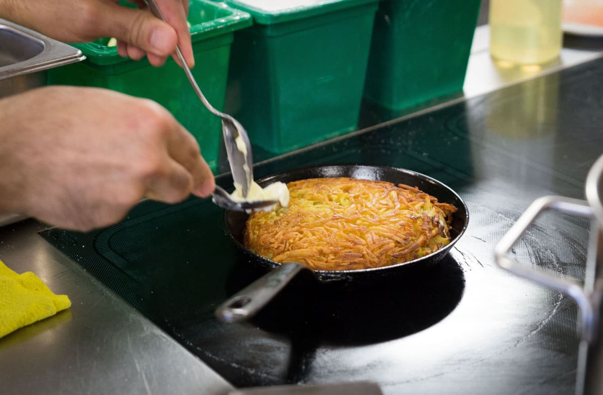 Sveitsiläisen ravintolan keittiössä valmistetaan röstiä