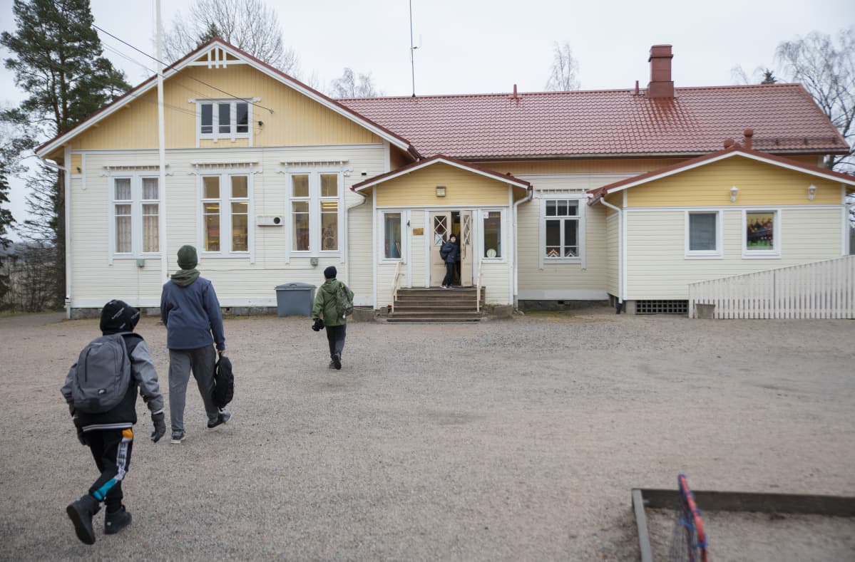 Ala-astelaiset juoksevat sisälle Hajalan kouluun.