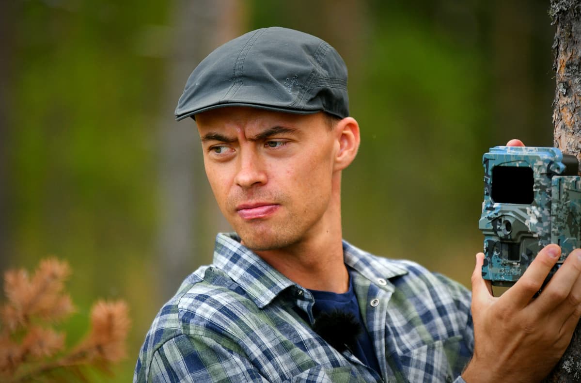 Perttu Hyvärinen virittää riistakameraa.