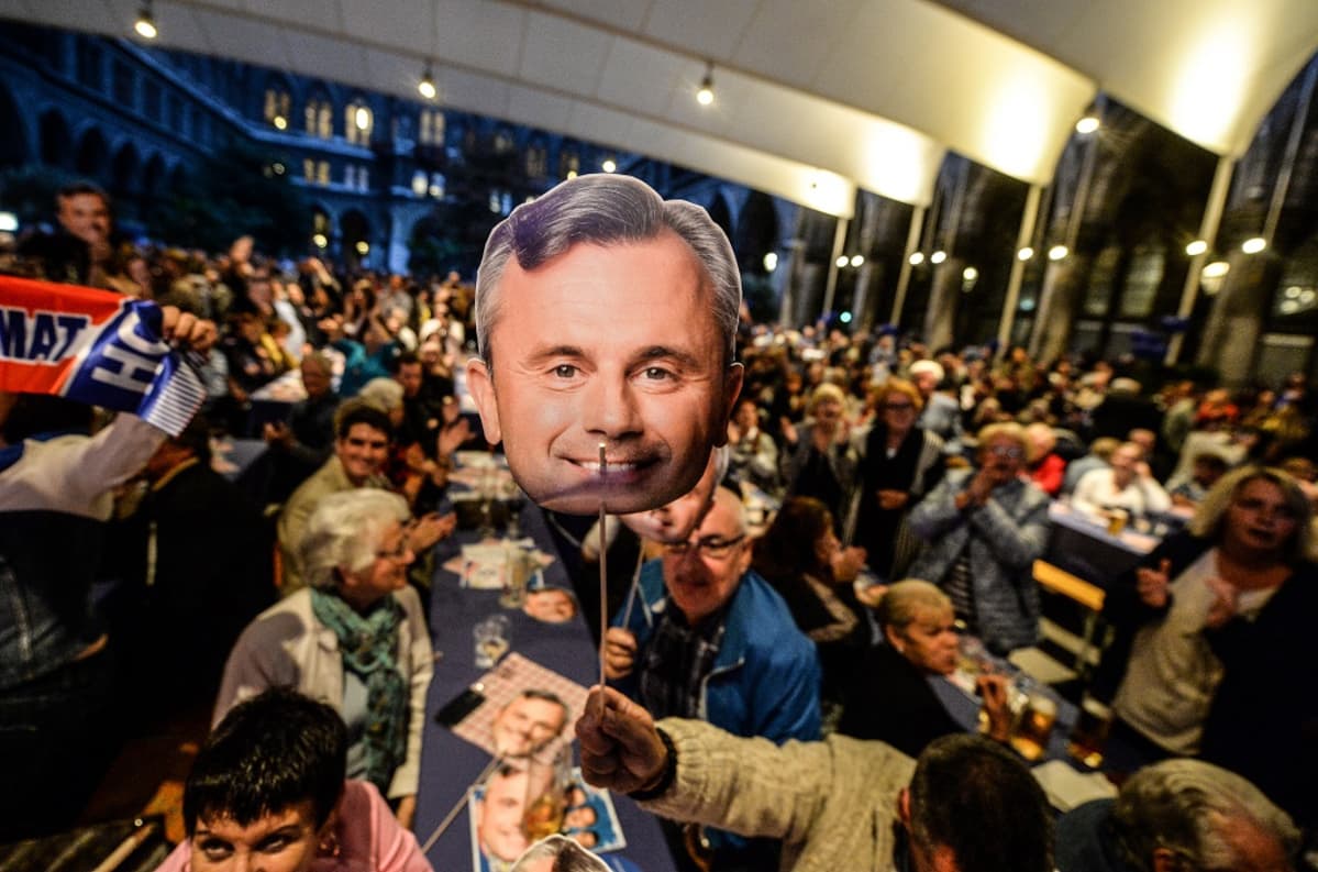 Väkijoukko nostelee keppeihin kiinnitettyjä Hoferin kasvokuvia.