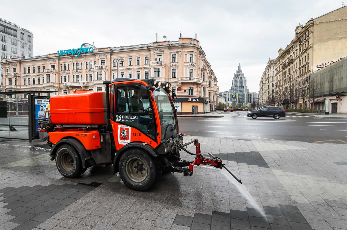 Kadulle ruiskutetaan desinfiointiainetta hiljaisessa Moskovan keskustassa.