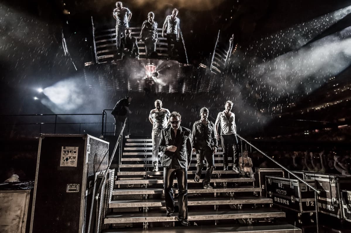 U2-bändi astelee alas 360-kiertueen lavalta rankassa vesisateessa Minneapoliksessa heinäkuussa 2011.