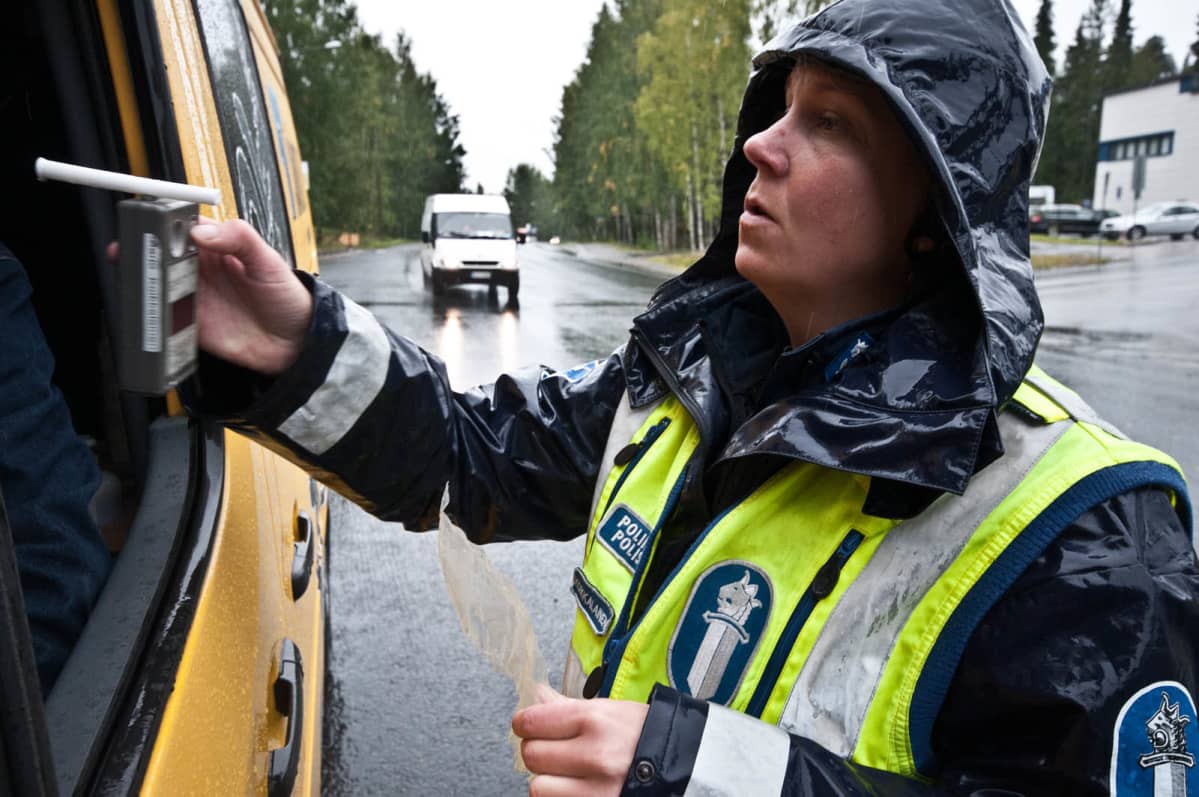 Poliisi puhalluttaa autoilijaa.