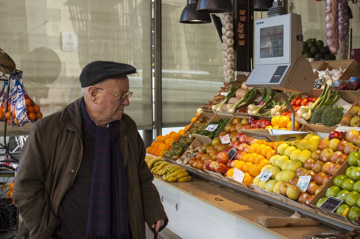 Mies katselee hedelmiä myyntikojussa. Espanjassa on päästy eroon pahimmasta talouskriisistä.