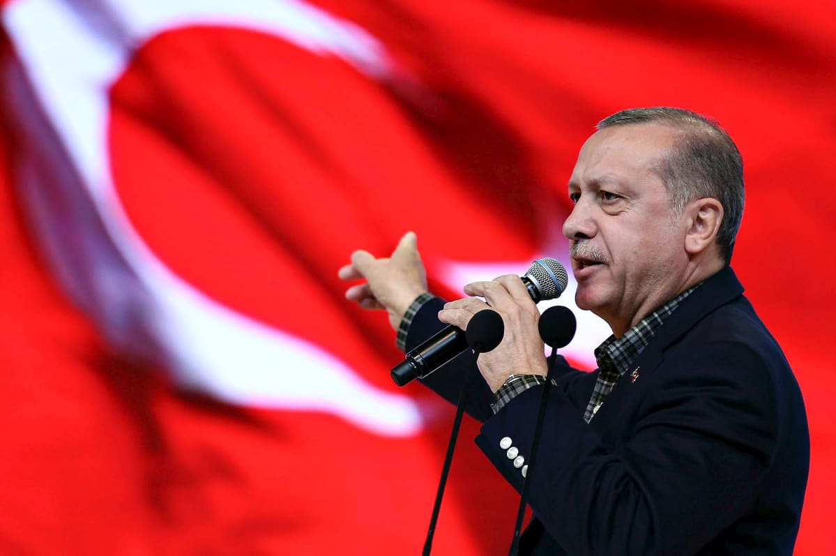 Turkin presidentti Recep Tayyip Erdoğan pitämässä puhettaan Istanbulissa. Takana liehuu punainen Turkin lippu.
