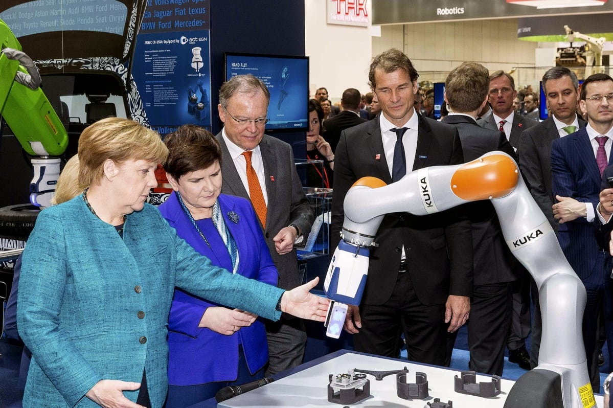 Angela Merkel ja Kuka-robotiikkaa.