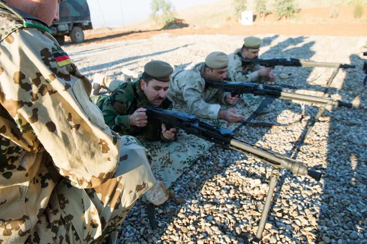 kurdisotilaita makuulla konekiväärien kanssa