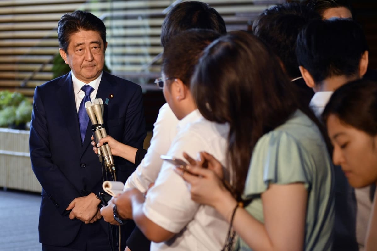 Pääministeri Shinzo Abe mikronit nenänsä edessä.