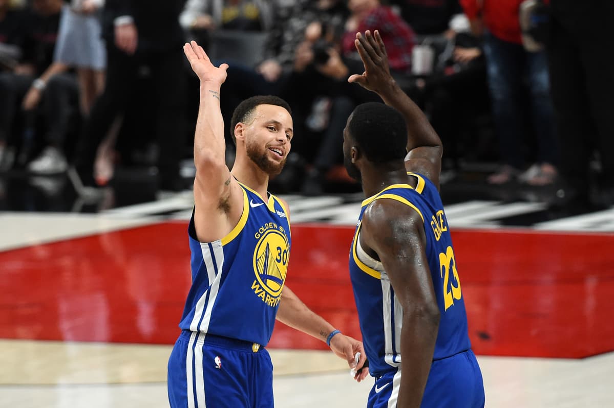Stephen Curry ja Draymond Green heittävät yläfemmat voiton jälkeen.