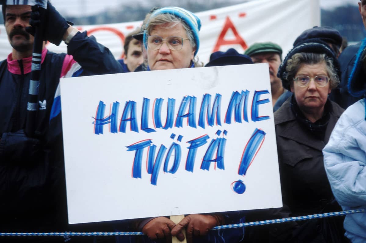 Historiallisessa kuvassa nainen osoittaa mieltään 1990-luvulla. Toiveena on saada työtä.