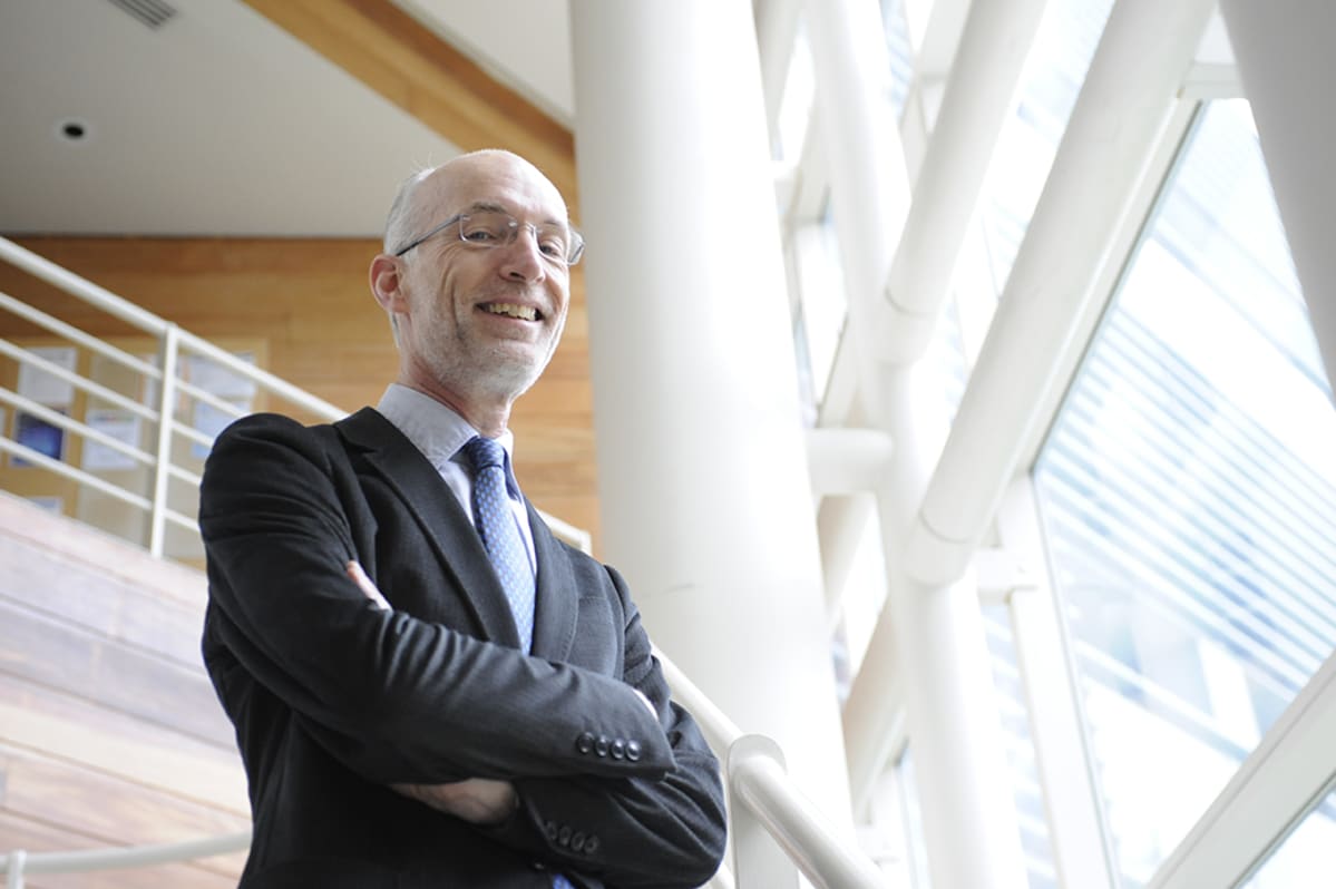 Professori Stuart Parkin kuvattuna avaraa toimistomaisemaa vasten.