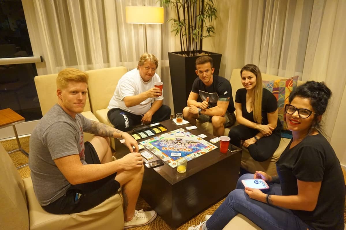 Ihmisiä Monopoly-pelilaudan ääressä.