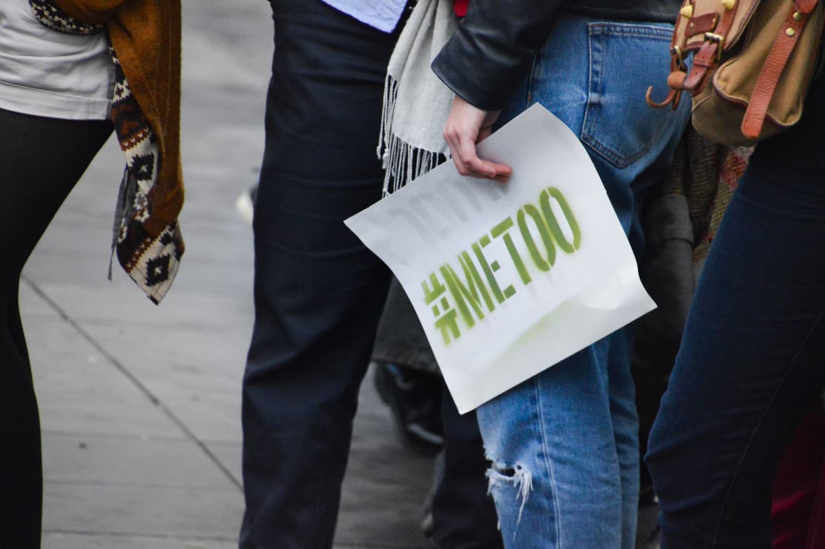 Naisen kädessä kyltti jossa lukee #MeToo