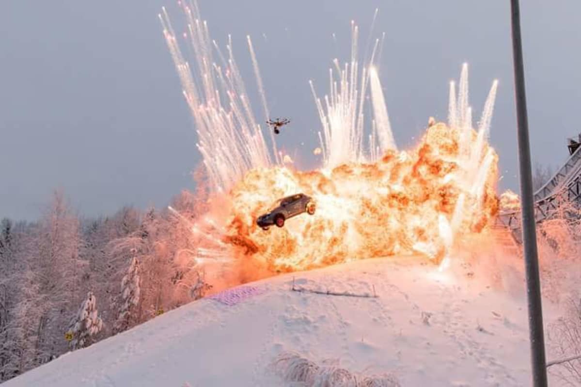 auto lentää alas hyppyrimäestä liekkien keskellä