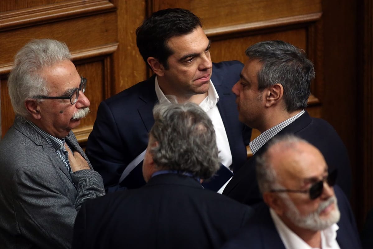 Kreikan pääministeri Alexis Tsipras odottaa äänestystulosta ministereiden keskellä.