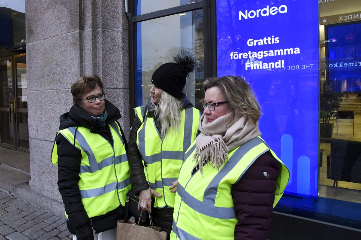 Lakkovahdit Minna Rytkönen (vas.), Minna Hamare (kesk.) ja Eija Mustonen suljetun Nordea-konttorin edessä Mannerheimintiellä Helsingissä torstaina 28. joulukuuta.