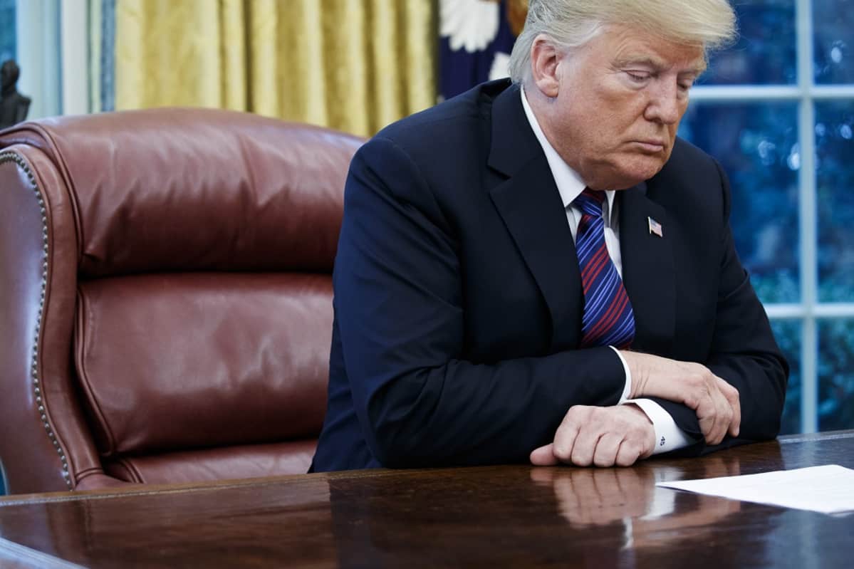 Donald Trump katsoo paperia.