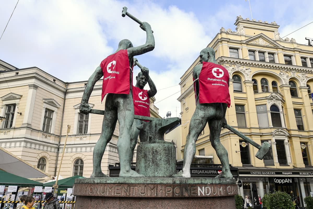 kolmella patsaalla punaisen ristin liivit