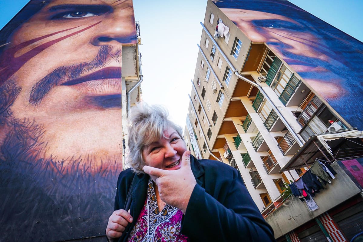 Aleida Guevara March isäänsä Ernesto Che Guevaraa esittävän muraalin edustalla Napolissa Italiassa.