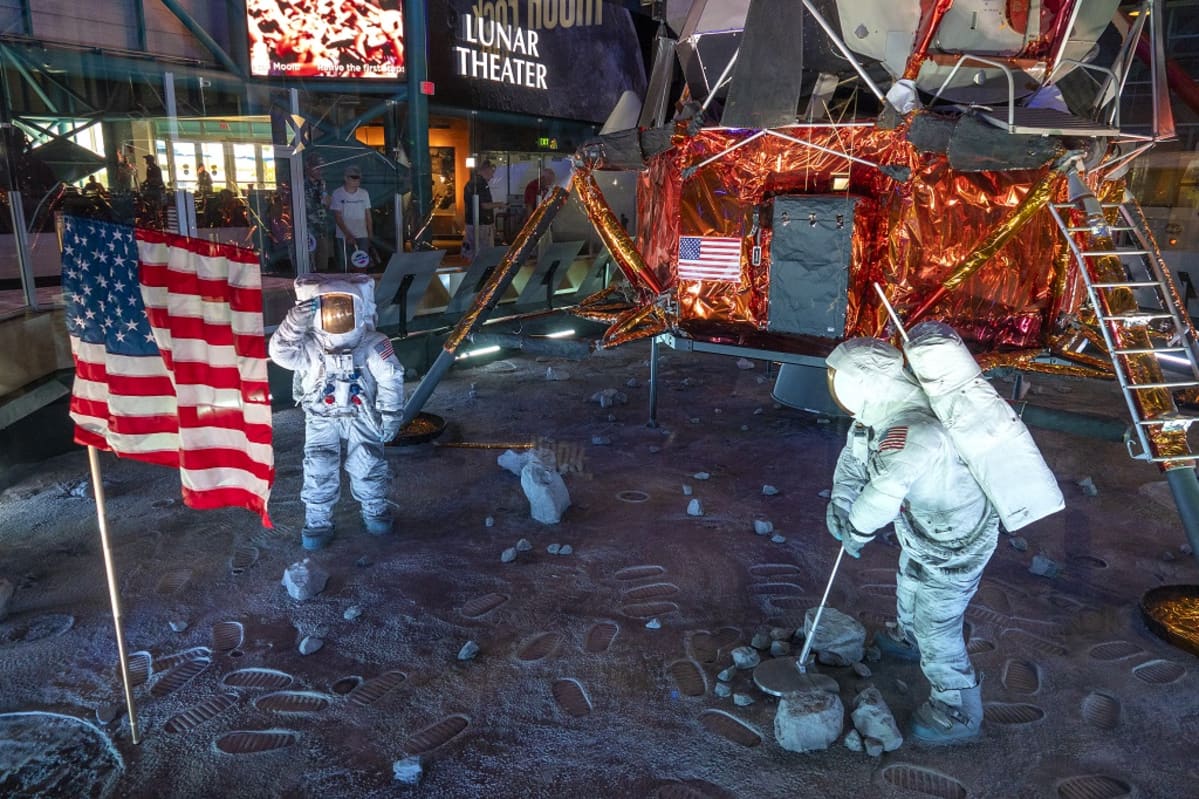Luonnollisen kokoinen kopio kuumoduulista, kahdesta astronautista ja Yhdysvaltain lipusta teatterin edustalla.