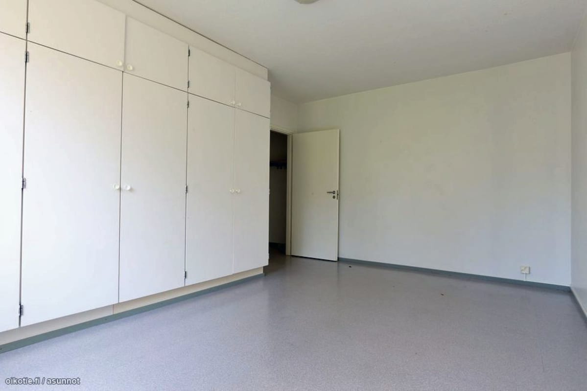 Huone, jossa seinällinen vaaleita kaappeja