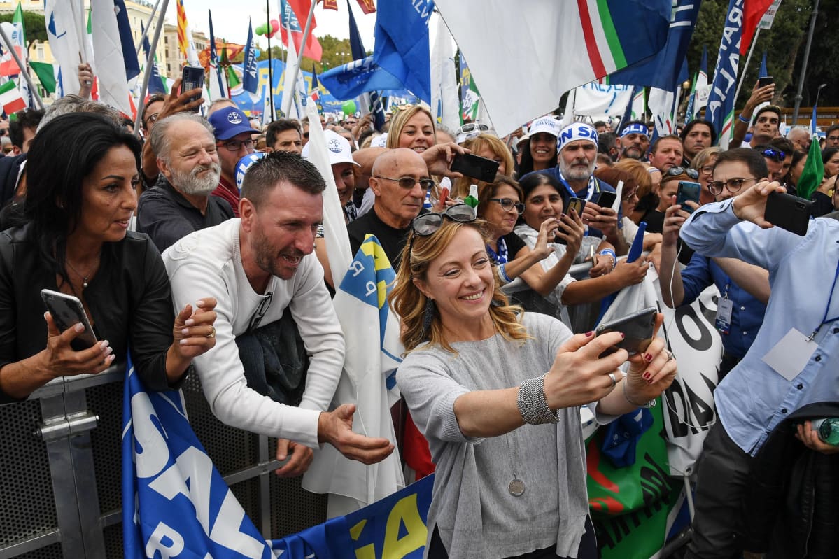 nainen ottaa selfien väkijoukko taustallaan