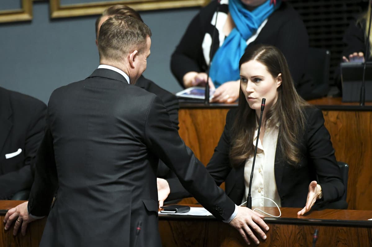 Pääministeri Sanna Marin keskustelee Kokoomuksen puheenjohtajan Petteri Orpon kanssa eduskunnan täysistunnossa.