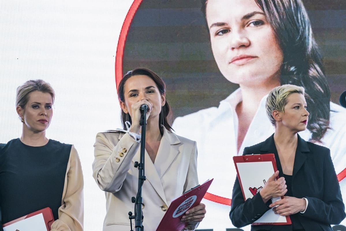 Opposition ehdokas Svjatlana Tsihanouskaja puhui kannattajilleen Minskissä. Taustalakanassa on hänen kuvansa.