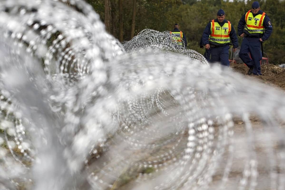 Poliisit partioivat piikilangasta rakennetun aidan äärellä syyskuussa Kroatian vastaisella rajalla Zakanyssa Unkarissa.