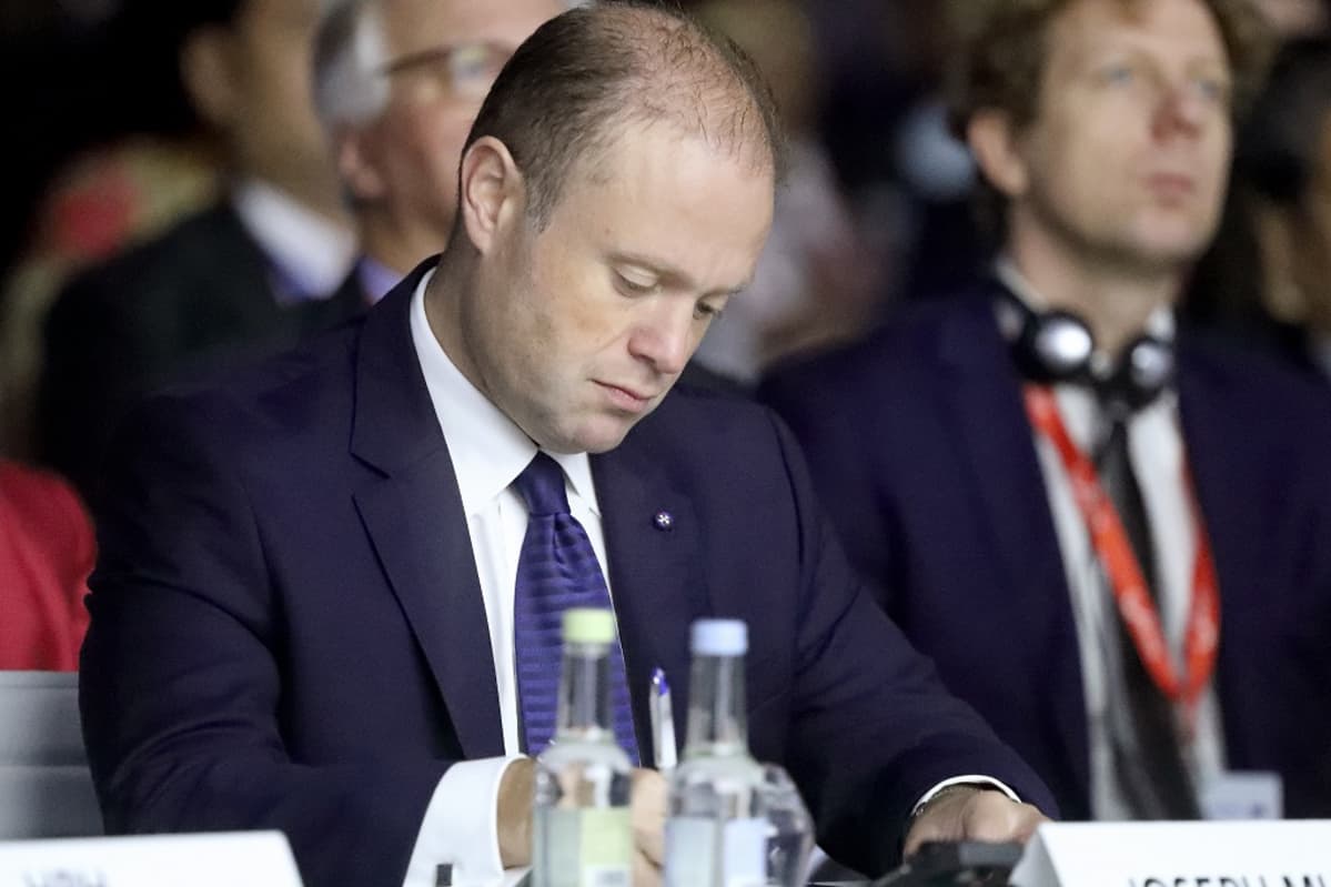 Pukuun pukeutunut mies istuu pöydän ääressä.