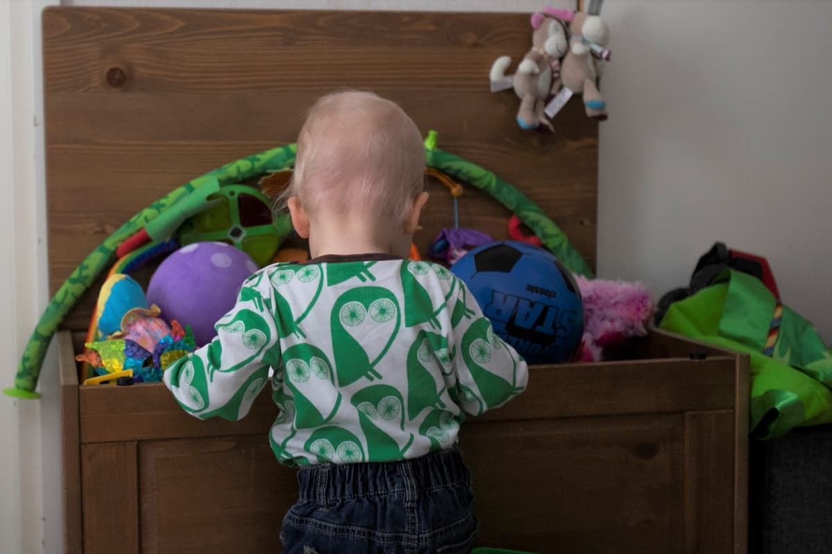 Lapsi kaivaa laatikosta leluja.