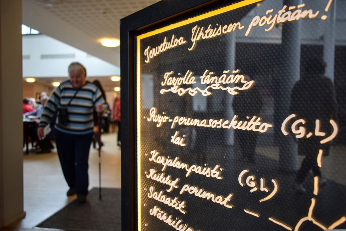 henkilö kävelykepin kanssa ruokalassa