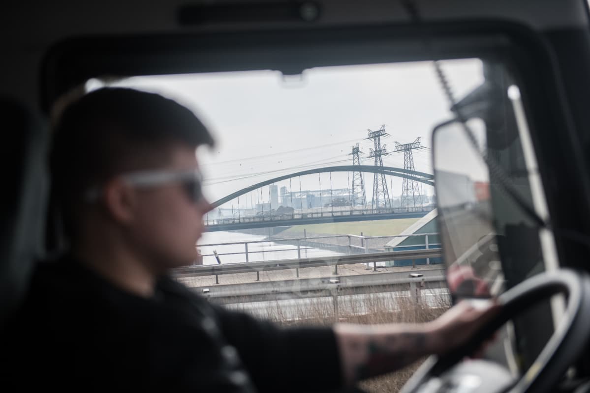 Sylwia Wedrichin kuorma-auton ikkunasta näkyy teollinen maisema autotien vieressä.