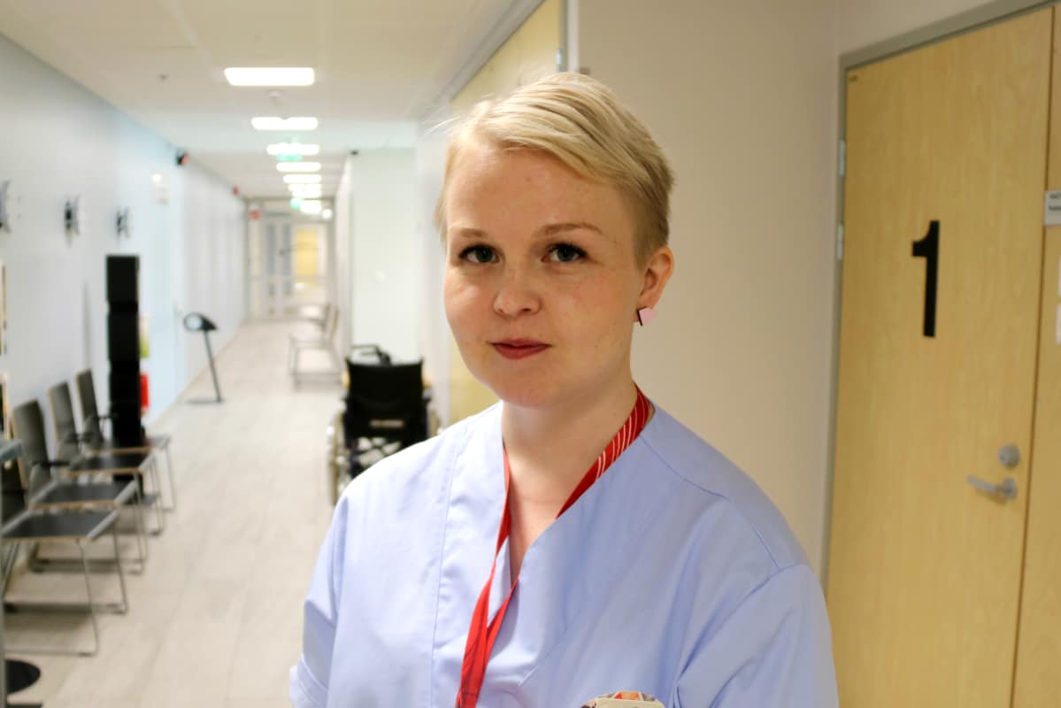 Sairaanhoitaja Marianne Pelo seisoo sairaalan käytävällä.