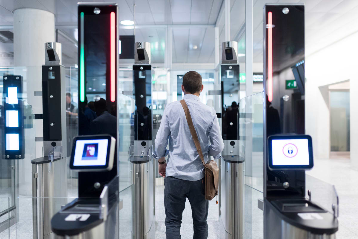 Mies menee automaattisen turvaportin läpi