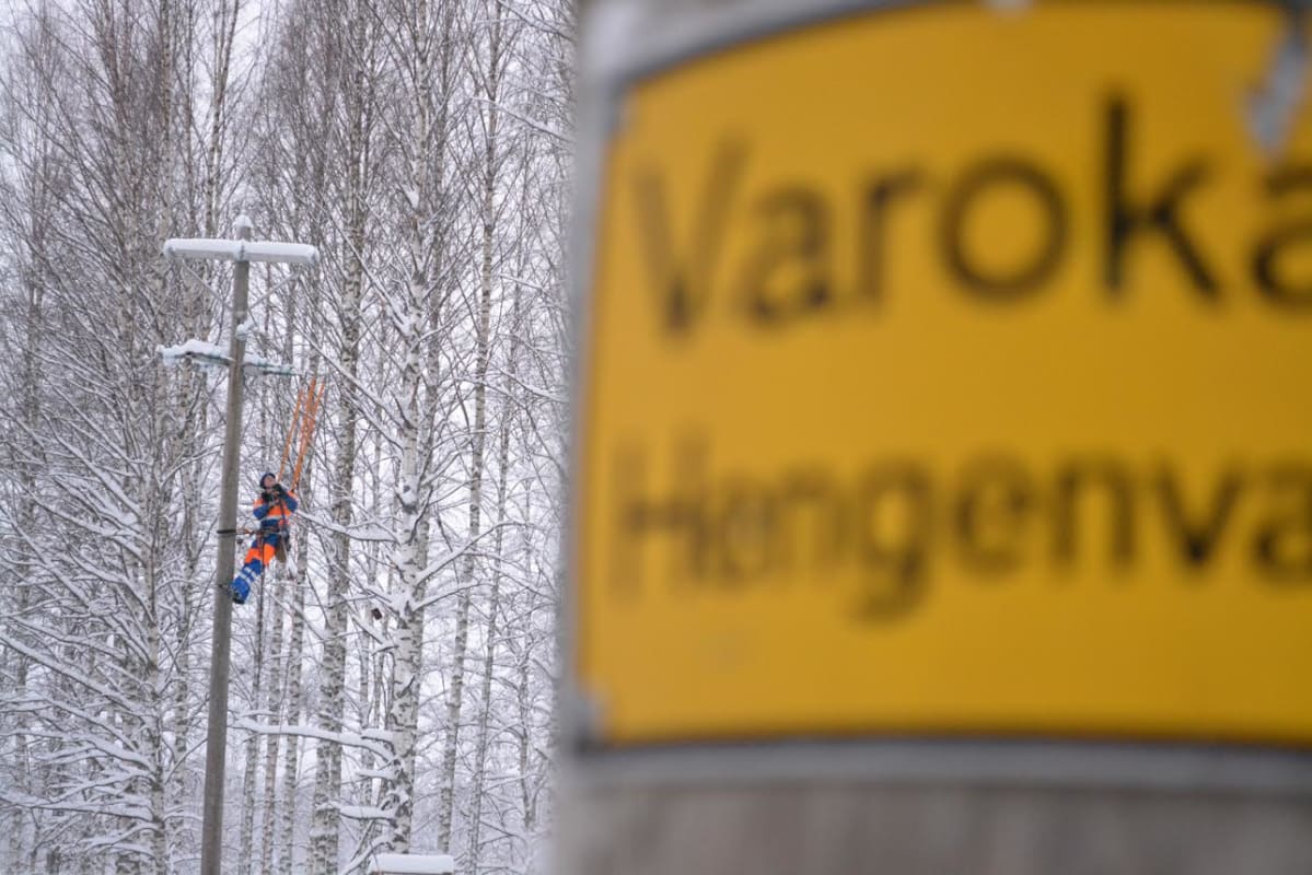 Sähköasentaja tolpassa taka-alalla, etualalla toinen sähkötolppa.