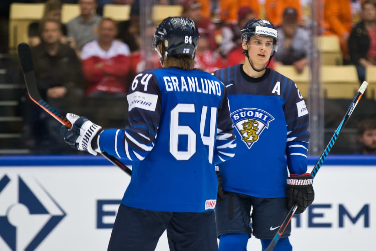 Mikael Granlund selin kameraan kaukalossa. Taustalla Sebastian Aho.