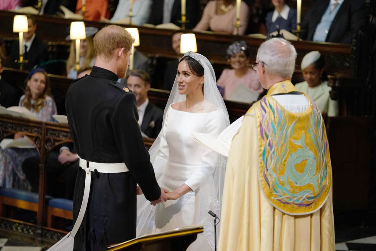 Prinssi Harry ja Meghan Markle pitävät toisiaan käsistä kiinni alttarilla.