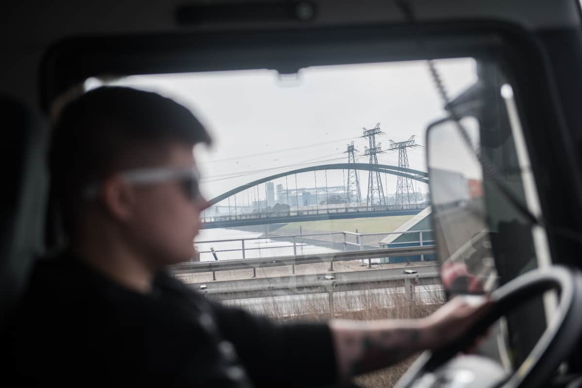 Sylwia Wedrichin kuorma-auton ikkunasta näkyy teollinen maisema autotien vieressä.
