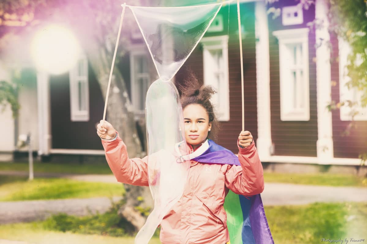 Nainen tekee isoja saippuakuplia.