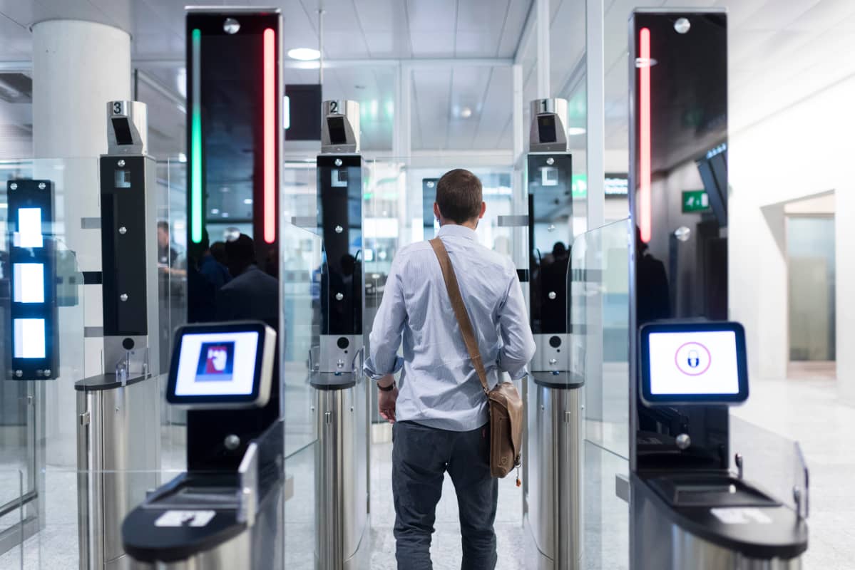 Mies menee automaattisen turvaportin läpi