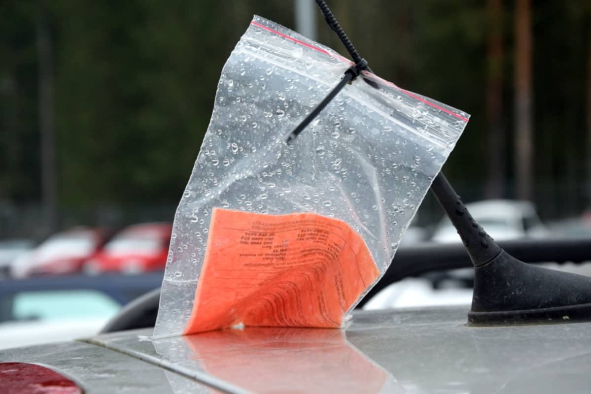 Auton antennissa oleva siirtokehotuslappu.
