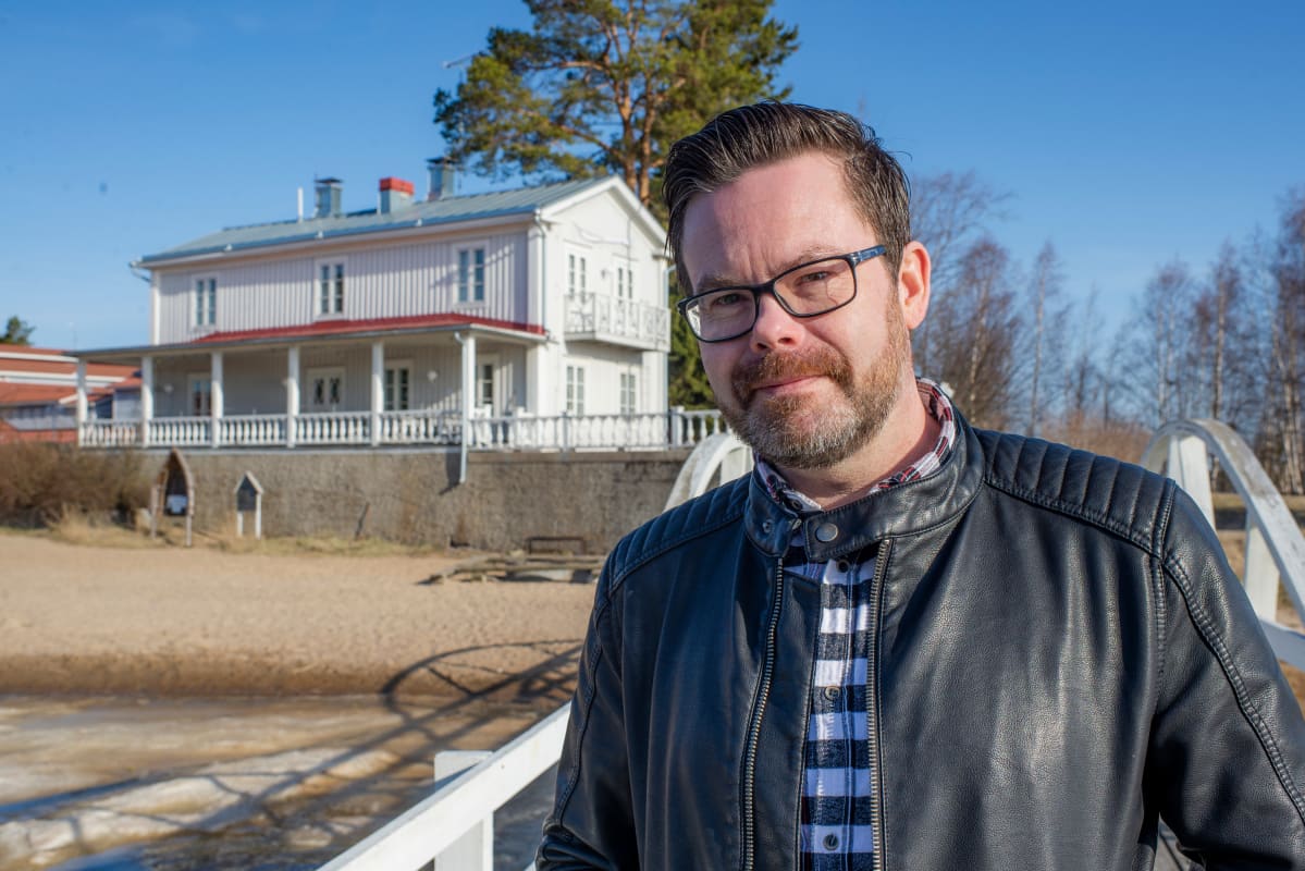 Kuvassa Janne Erkkilä seisoo laiturilla. Taustalla on hääpaikkana toiminut Villa Elba.