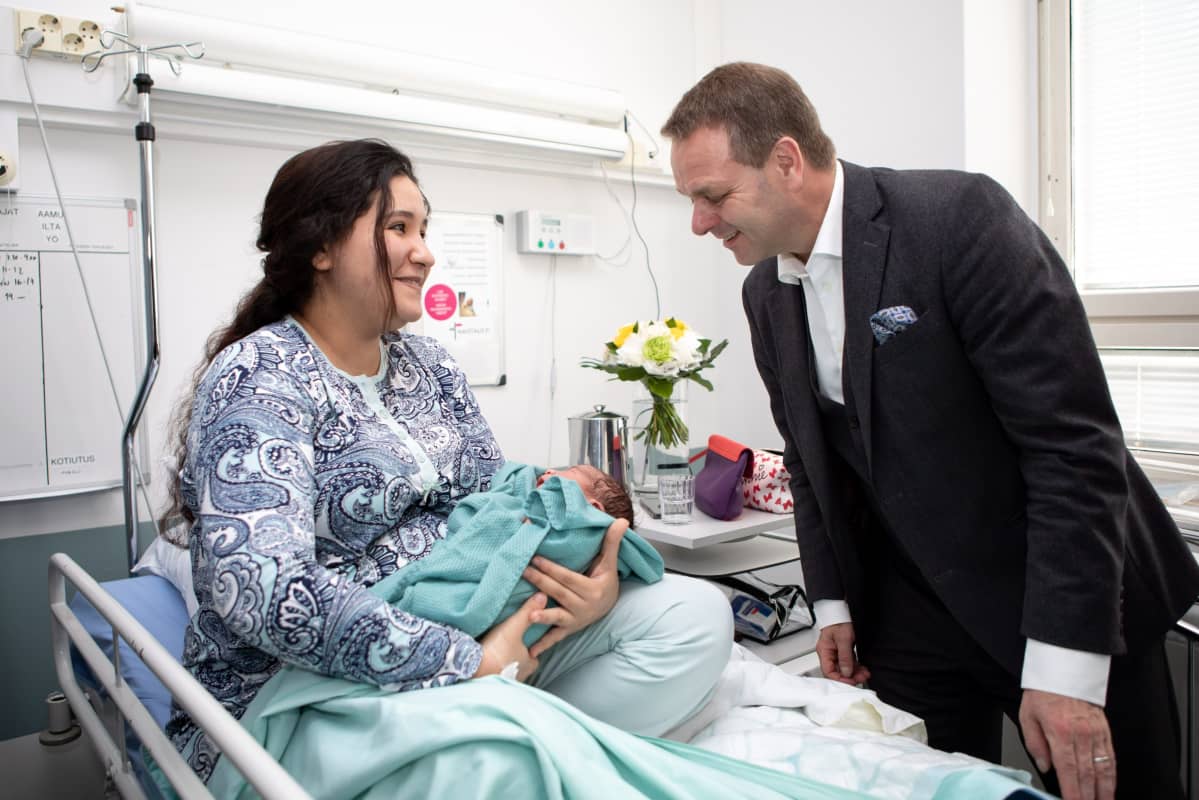 Helsinki-päivän vauva äitinsä Imane Kafin sylissä ja vieressä Helsingin pormestari Jan Vapaavuoren Naistenklinikalla Helsingissä 12. kesäkuuta 2019.