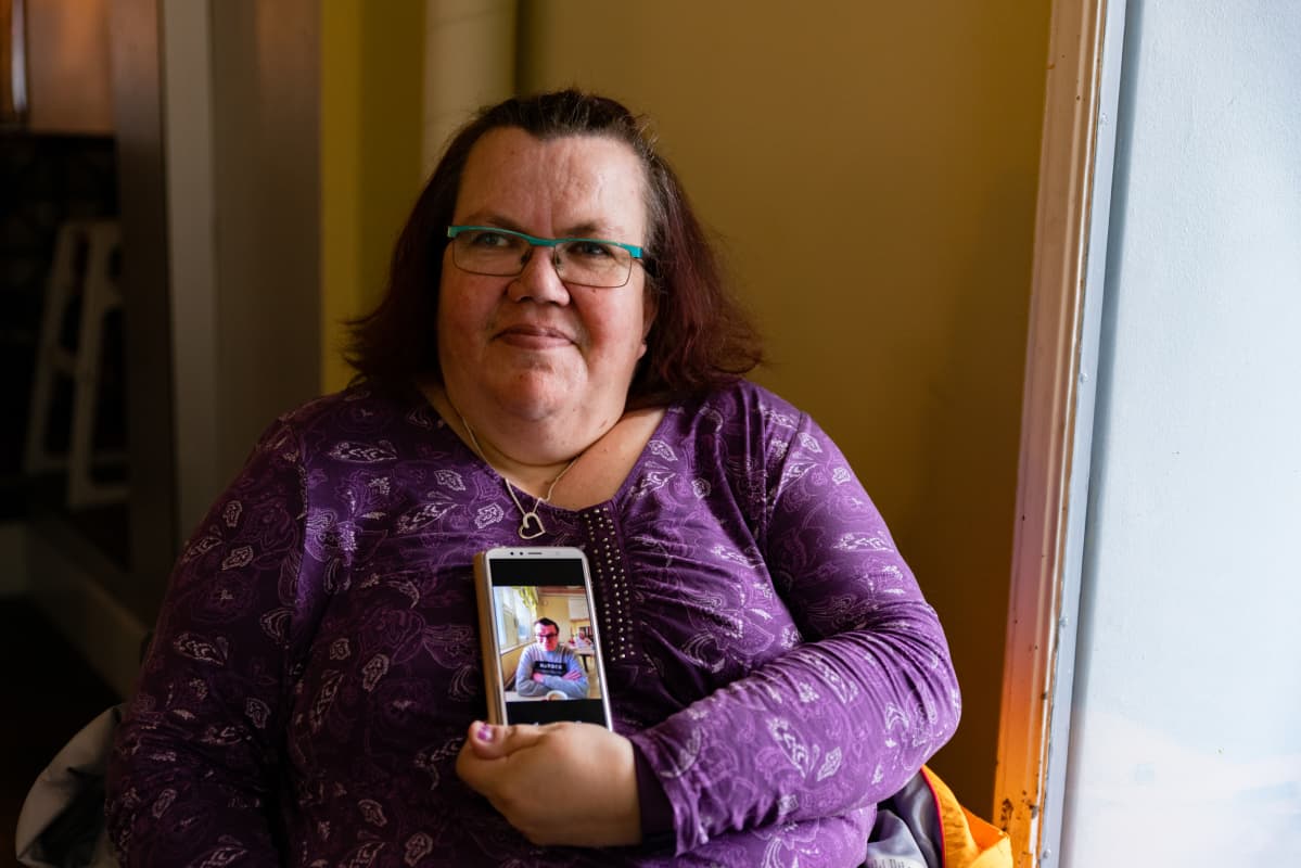Jaana Nordlund esittelee miehensä Aimon kuvaa puhelimeltaan Tampereen rautatieasemalla