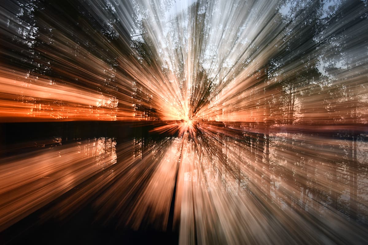 Auringonnousu kuvattuna zoomaten valotuksen aikana. Aamuinen horisontti on muuttunut säteiksi.