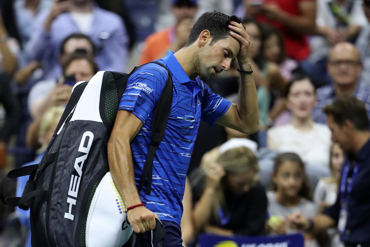 Novak Djokovic kävelee pää painuksissa pois kentältä.